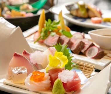 Assorted sashimi and garnishes on ceramic plates in ryokan dining at Yufuin Onsen Hinoharu Ryokan, Ōita