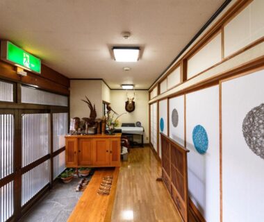 Wooden floored entrance corridor with sliding fusuma doors at Yufuin Onsen Oyado Jinnouchi in Ōita, Kyūshū
