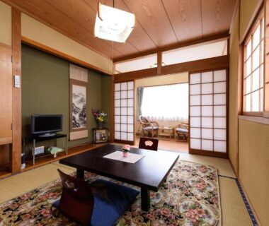 Traditional tatami room with low table and shoji screens at Yufuin Onsen Oyado Jinnouchi in Ōita, Kyūshū