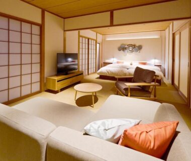 Spacious tatami room with sofa, low table, shoji screens and twin beds at Yufuin Rakuyu in Ōita
