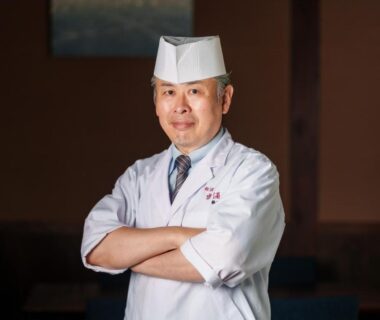Ryokan chef in white coat and hat with arms crossed at Yufuin Rakuyu, Ōita