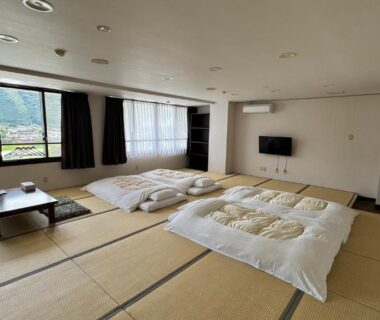 Tatami room with futons and low table at Yufuin Ryokan Yamanami, Ōita