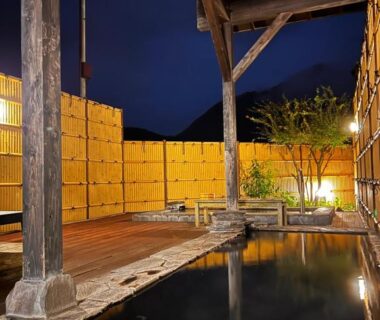 Wooden outdoor onsen and deck with bamboo fence at Yufuin Ryokan Yamanami in Ōita, Kyushu
