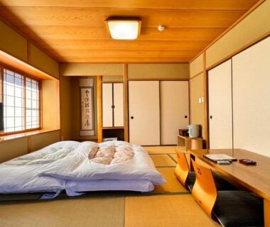 Traditional tatami room with futons, low table and shoji screens at Yufuin Ryokan Yamanami in Ōita, Kyushu