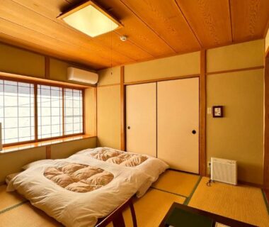 Tatami room with futon and shoji window at Yufuin Ryokan Yamanami, Oita