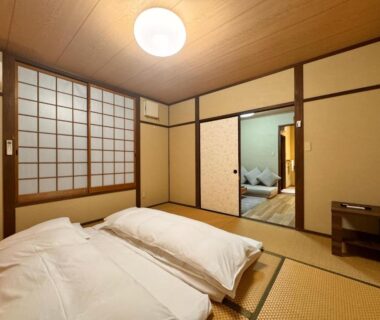 Traditional tatami room with futons, shoji screens and sliding doors at Yufuin Ryokan Yufumomiji in Ōita, Kyūshū