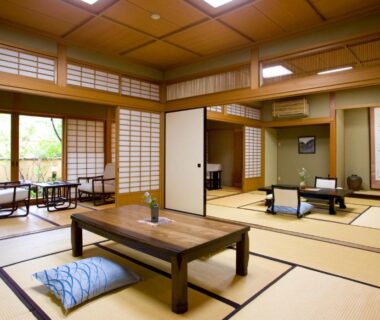 Traditional tatami room with low table, zabuton cushions, shoji screens and garden-facing windows at Yufuin Santoukan