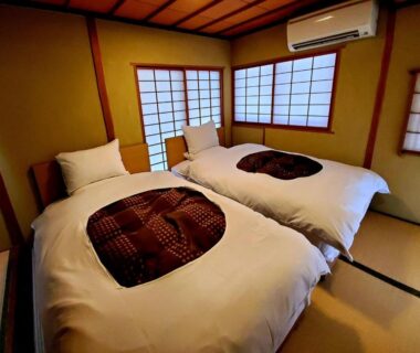 Twin futon beds on tatami with shoji screens at Yufuin Santoukan in Ōita, Kyūshū