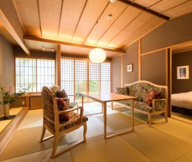 Traditional tatami room with low table, shoji screens, seating and bed at Yufuin Souan Kosumosu Oita