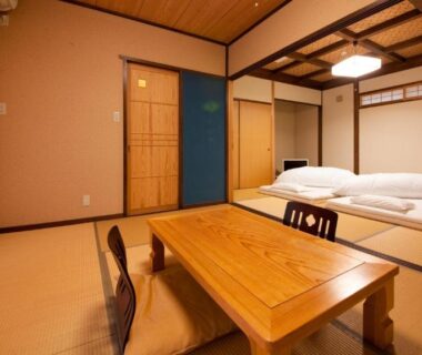 Traditional tatami room with futon, low wooden table and shoji screens at Yufuin Tsubaki, Ōita, Kyushu