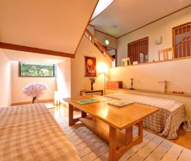 Traditional tatami room with low wooden table, floor cushions, shoji screens and raised seating area at Yufuin Yamaboushi