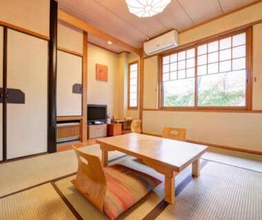 Tatami room with low wooden table and floor chairs at Yufuin Yamaboushi in Ōita, Kyūshū