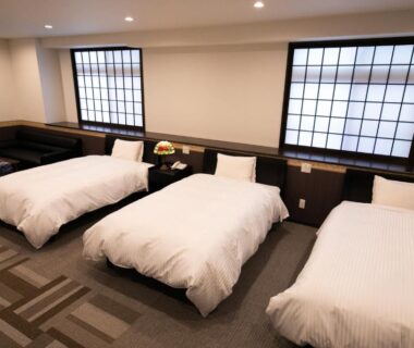 Three single beds with shoji windows and carpeted floor in Yufuin Yasuha room, Ōita, Kyūshū, Japan