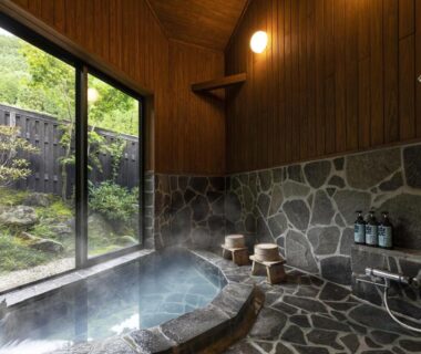 Indoor stone onsen bath at Yufuin Yufusaryo with garden view in Oita, Kyushu, Japan