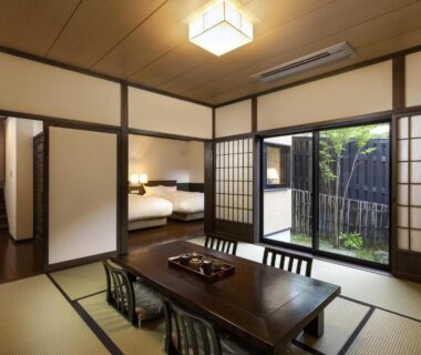 Tatami room with low table, shoji screens and small garden view at Yufuin Yufusaryo in Ōita, Kyūshū