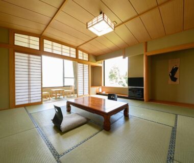 Spacious tatami room with low table, zabuton cushions and shoji screens at YufuinOnsenRyokan Mebaeso, Ōita