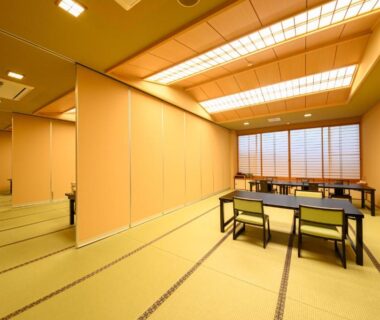 Large tatami dining space with low tables, chairs and sliding shoji screens at YufuinOnsenRyokan Mebaeso Ōita