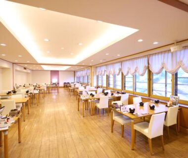 Spacious wooden dining room with tables and large windows at Yugawara Chiyodasou, Kanagawa, Kantō, Japan