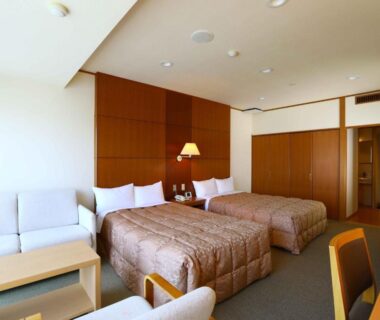 Twin beds with sofa and table at Yugawara Chiyodasou in Kanagawa, Japan