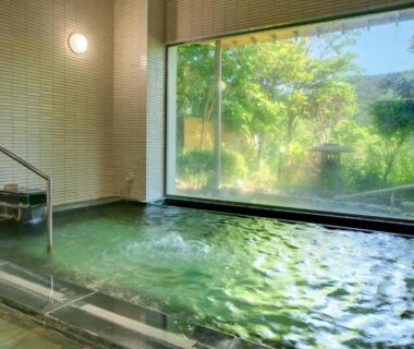 Indoor onsen with large glass window overlooking garden at Yugawara-Onsen GREENPAL YUGAWARA in Kanagawa
