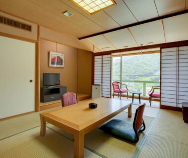 Tatami room with low table, zabuton cushions, shoji screens and balcony chairs at GREENPAL YUGAWARA