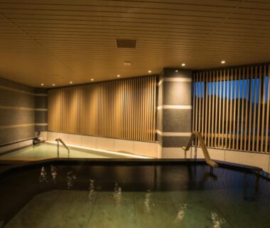 Indoor onsen bath with wooden slatted screens and handrail at Yugawara-Onsen Hotel Shiroyama, Kanagawa