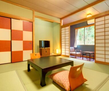 Traditional tatami room with low table, zaisu chairs, patterned sliding panels and garden view window