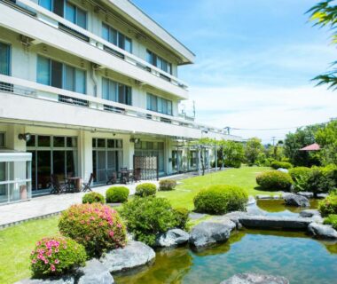 Exterior view of Yugawara-Onsen Manyoso with landscaped garden, stone-lined pond and guest terrace in Kanagawa