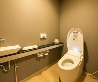 Compact bathroom with modern toilet, sink, and shelf at Yugawara Onsen Mizuno-kaori Kanagawa