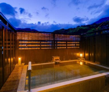 Evening outdoor onsen bath with wooden fencing and mountain backdrop at Yugawara Onsen Mizuno-kaori, Kanagawa