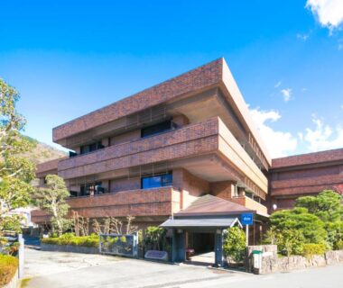 Exterior view of Yugawara-Onsen SUGINA in Kanagawa, multi-story brick building with landscaped entrance
