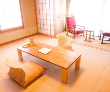 Tatami room with low wooden table, zabuton cushions and shoji screens at Yugawara Retreat Goen no Mori in Kanagawa