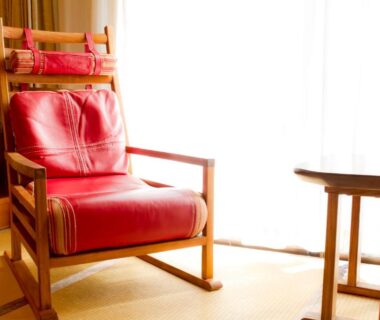 Red armchair on tatami beside wooden side table and shoji-lit window at Yugawara Retreat Goen no Mori, Kanagawa