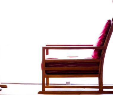 Wooden armchair with red cushion by bright window in Yugawara Retreat Goen no Mori seating area, Kanagawa