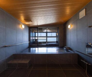 Tiled indoor onsen bathing area with wooden ceiling at YuhigauraOnsen Umi no Hana, Kyoto