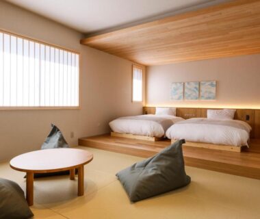 Minimal tatami room with low round table and raised twin beds at YuhigauraOnsen Umi no Hana Kyoto