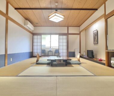Spacious tatami room with low table and shoji screens at Yuhigauraonsen ShizukaHanaogi Kyoto