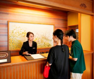 Guests checking in at wooden reception counter of Yuhigauraonsen ShizukaHanaogi in Kyoto Kansai