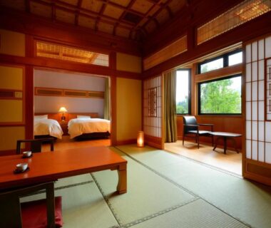 Tatami room with low table, twin beds and shoji screens at Yukaen in Iwate, Tōhoku, Japan