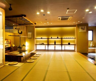 Spacious tatami room with low seating, decorative shelving and warm lighting at Yukimurasaki in Chūbu, Gifu