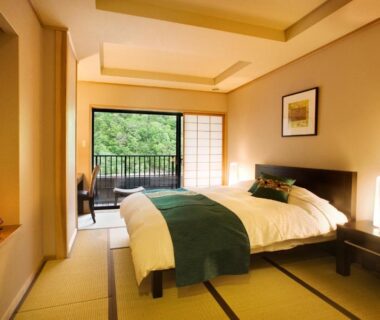 Tatami-floored guest room with Western bed, shoji screens and balcony at Yukimurasaki in Gifu Chūbu Japan