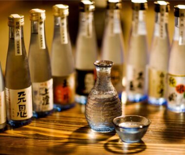 Tokkuri and sake cups with bottles on wooden counter at Yukimurasaki in Gifu, Chubu