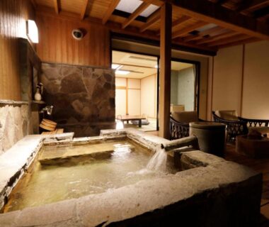 Stone onsen bath with tatami sitting area at Yumeguri no Yado Yoshiharu in Shizuoka
