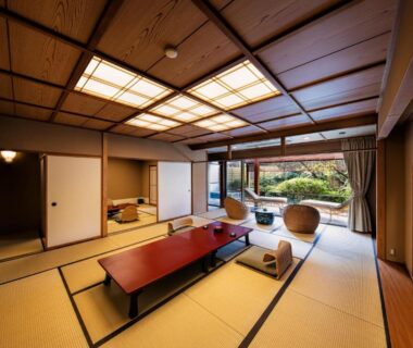 Spacious tatami room with low table, shoji screens, seating and garden view at Yumeguri no Yado Yoshiharu Shizuoka