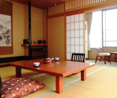 Traditional tatami room with low table, floor cushions, shoji screens and window seating at Yumoto Choseikan in Gunma