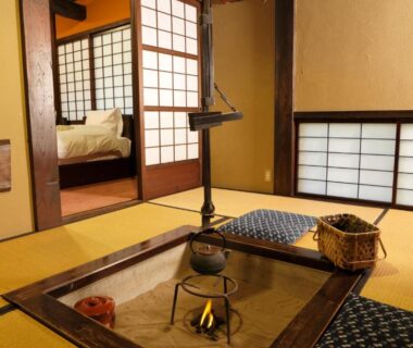 Sunken irori hearth with hanging kettle in tatami room, shoji screens and futon at Yumoto Choza, Gifu
