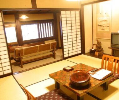 Tatami room with low table, shoji screens, tokonoma and television at Yumoto Choza in Gifu