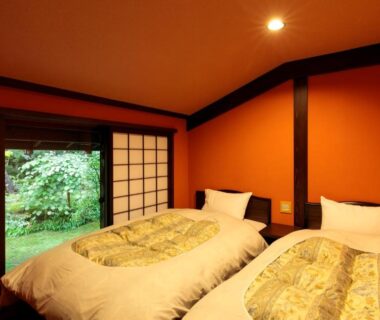 Twin beds on tatami with shoji sliding door opening to a garden at Yumoto Choza, Gifu