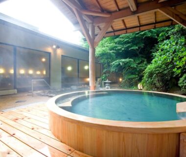 Circular wooden onsen bath on covered deck at Yumoto Fujiya Hotel in Kanagawa