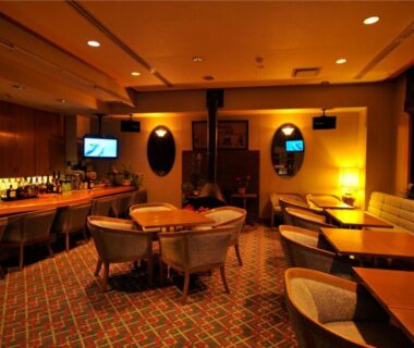 Intimate bar lounge with circular table, upholstered seating and carpeted floor at Yumoto Itaya in Kanto
